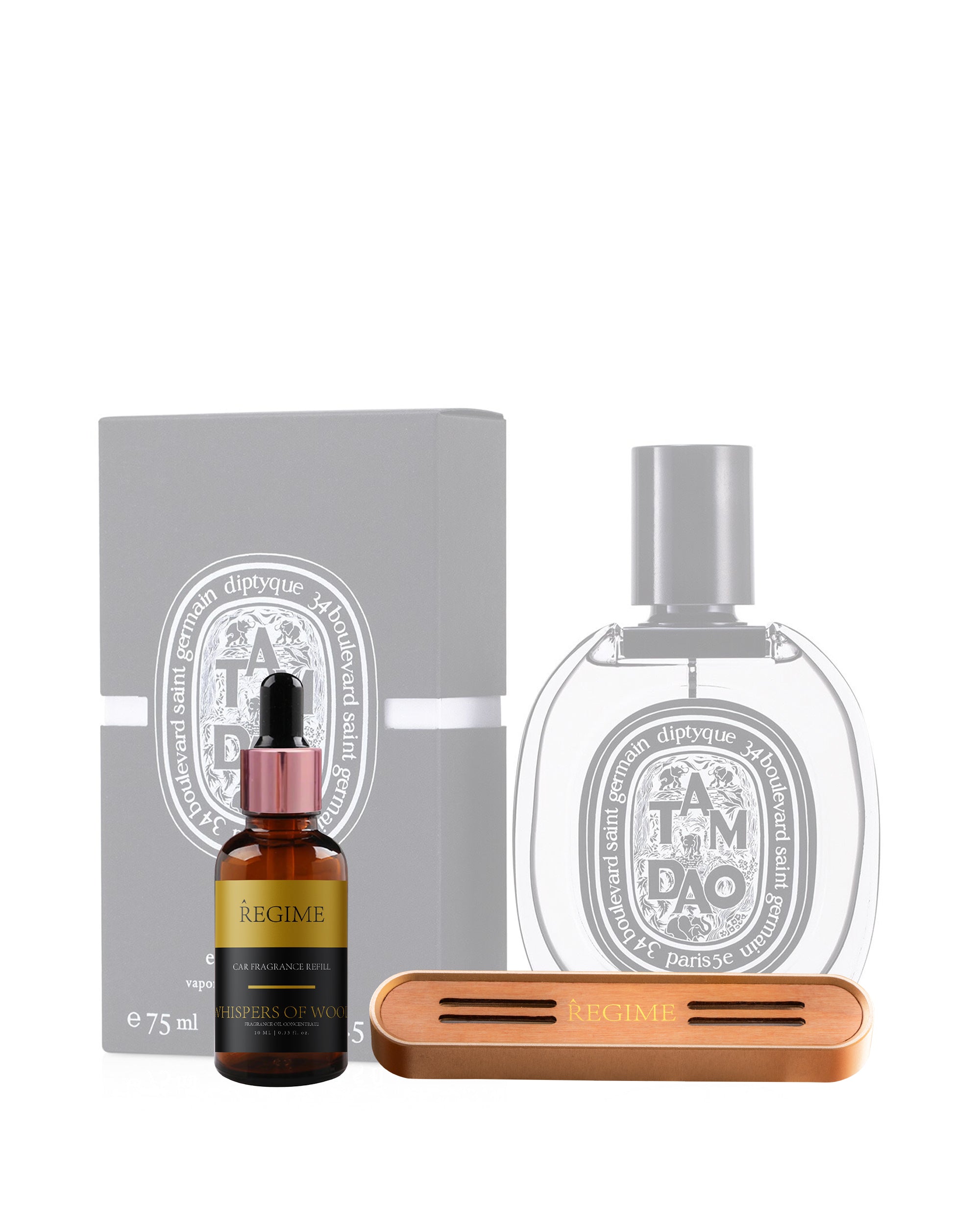 A subtle, Dim behind with Diptyque Tam Dao perfume for men; in the foreground, a Diptyque Tam Dao inspired fragrance oil dropper bottle and a Regime Fragrances car air freshener vent clip featuring a rose gold metal body and inserted wooden front panel for scent release.